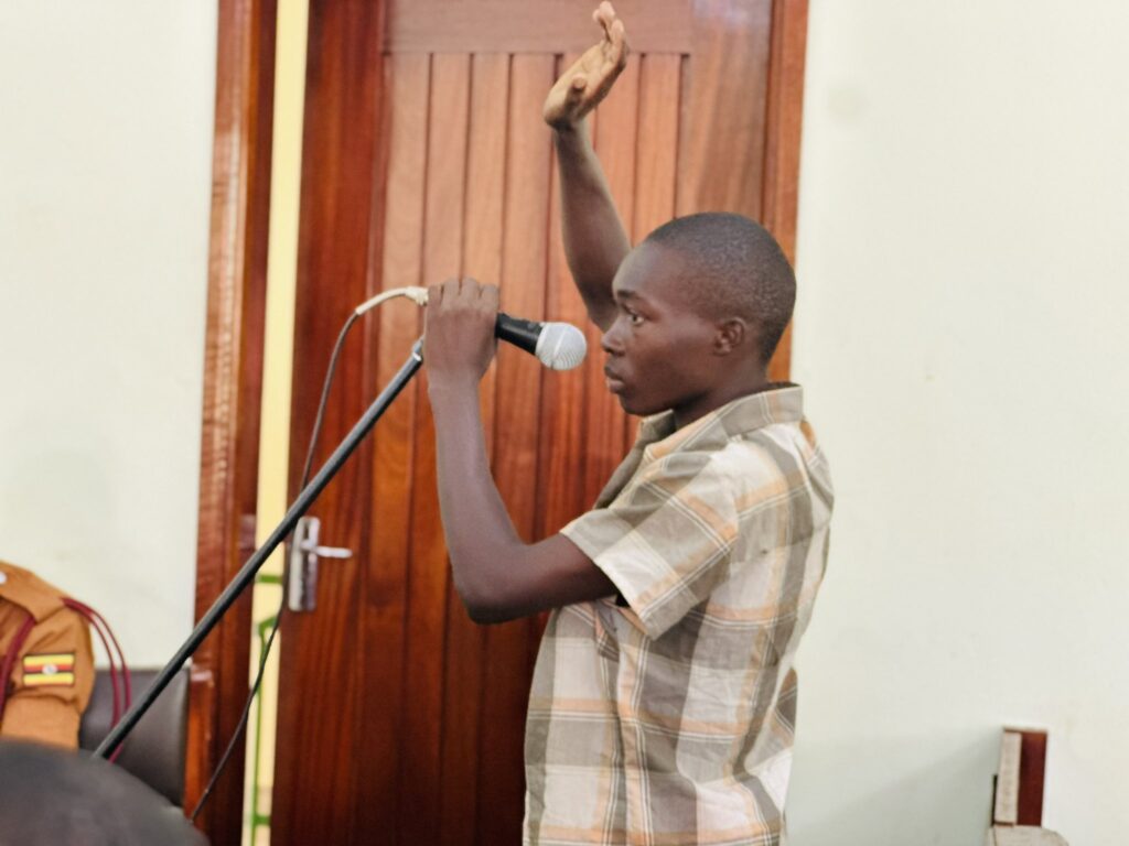 a man holding a microphone and raising his hand, Nabugodi Emmanuel